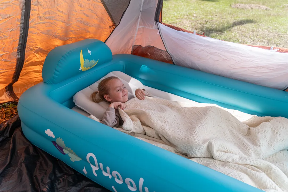 Girl sleeping peacefully in the Quooly bed inside a camping tent