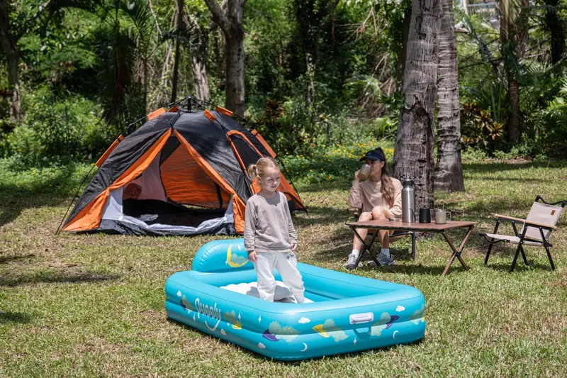 Girl playing in the Quooly bed at an outdoor campsite